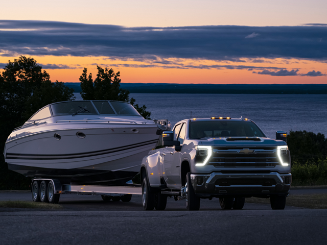 A photo of a 2024 Chevrolet Silverado 3500 HD towing a boat