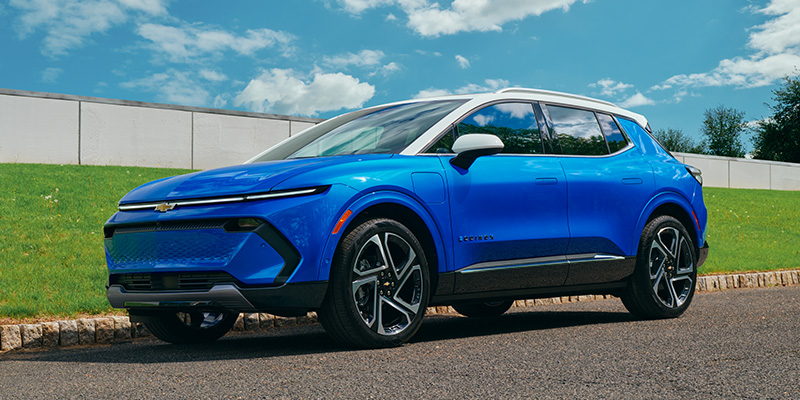 Blue Chevrolet Equinox EV parked on a roadside.