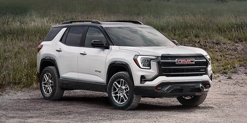 White GMC Terrain AT4 SUV parked on a rugged gravel trail.